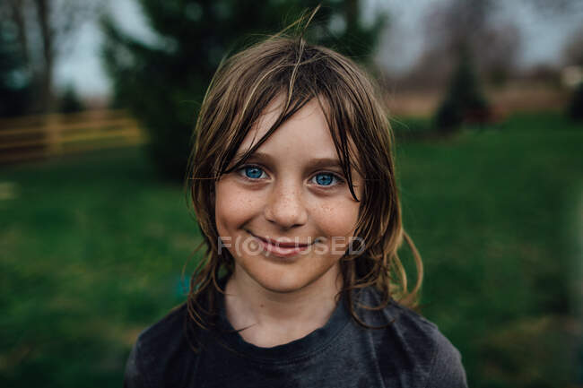 Kleiner Junge blickt mit einem Lächeln in die Kamera — Stockfoto
