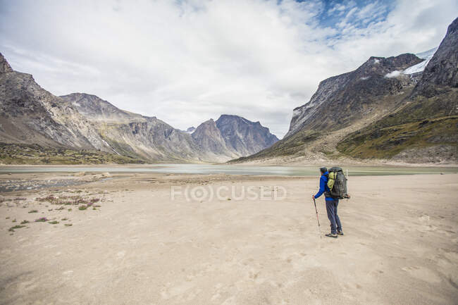 Rear view of a backpacker looking at the route ahead. — Stock Photo