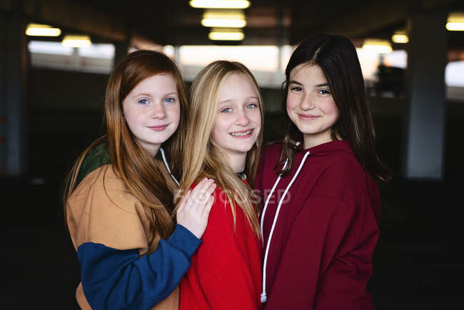 Three cute and happy tween girls standing together. — Stock Photo