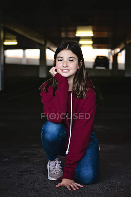 Beautiful tween girl with long dark hair smiling in the city. — Stock Photo