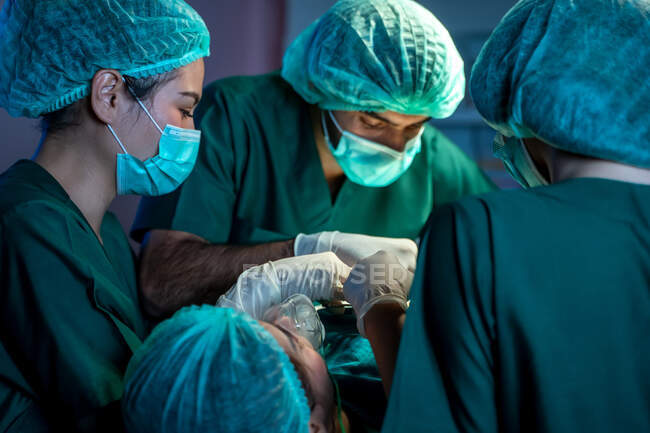 Хирурги с ассистентами работают в операционной в больнице, медицинская команда выполняет операции. — стоковое фото