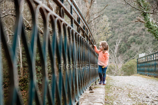 Petite fille marche le long du vieux pont métallique en France — Photo de stock