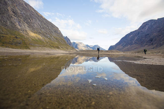Reflection of backpackers in Akshayuk Pass, Baffin Island. — Stock Photo