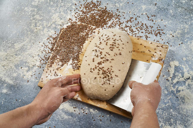 Recoger la masa de pan artesanal con espátula - foto de stock