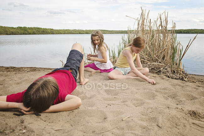 Enfants jouant au bord d'un lac — Photo de stock