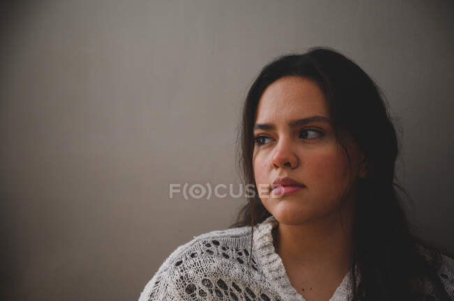 Portrait d'une jeune femme hispanique béatifique sur fond gris — Photo de stock