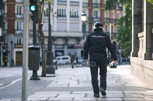 Policial membro das forças de segurança espanholas e corpos que caminham por uma rua da cidade — Fotografia de Stock