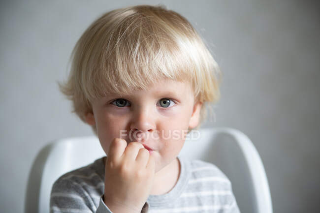 Caucasian boy eating in the kitchen, lifestyle portrait. — Stock Photo