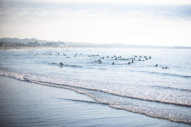Crowded Narragansett Beach surf lineup at sunrise in summer — Stock Photo