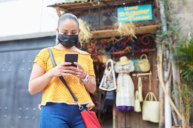 Mujer joven con máscaras fuera de un mercado de artesanía local - foto de stock