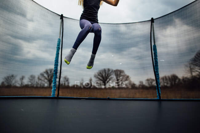 Giovane ragazza che salta su un trampolino — Foto stock