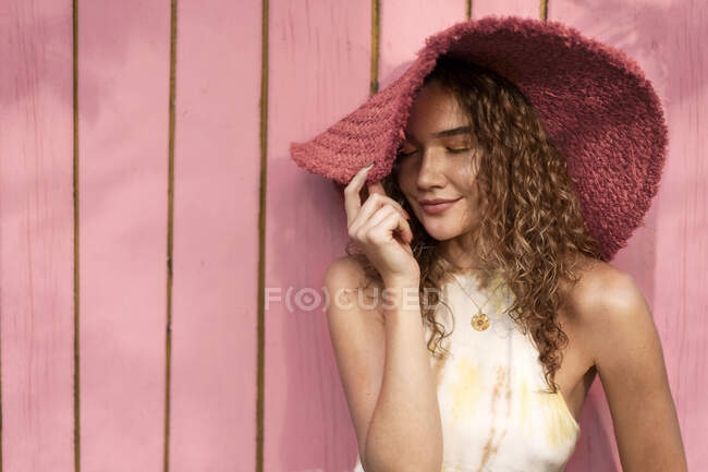 Retrato de una hermosa chica de moda con el pelo rizado en un amarillo - foto de stock