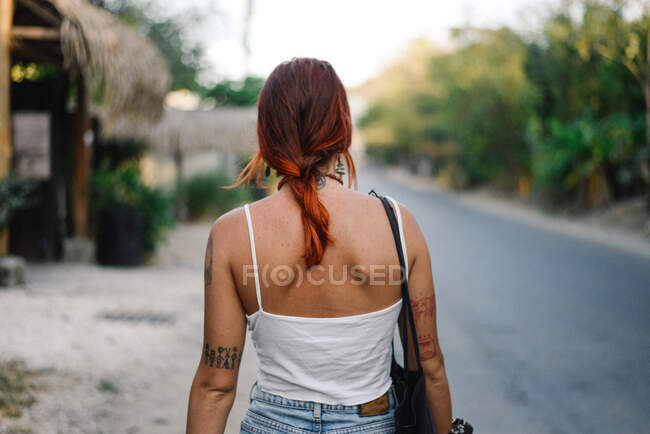 Uma linda menina ruiva caminha pela rua — Fotografia de Stock