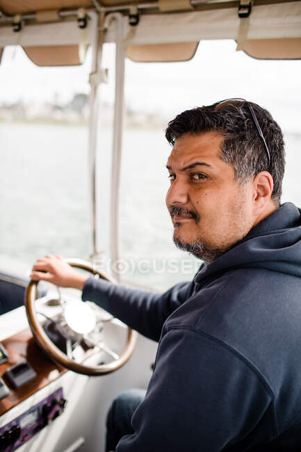 Mittvierziger hispanischer Mann fährt Boot in der Bucht von San Diego — Stockfoto
