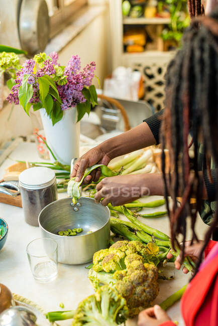 Femme noire au travail avec des légumes dans la cuisine — Photo de stock