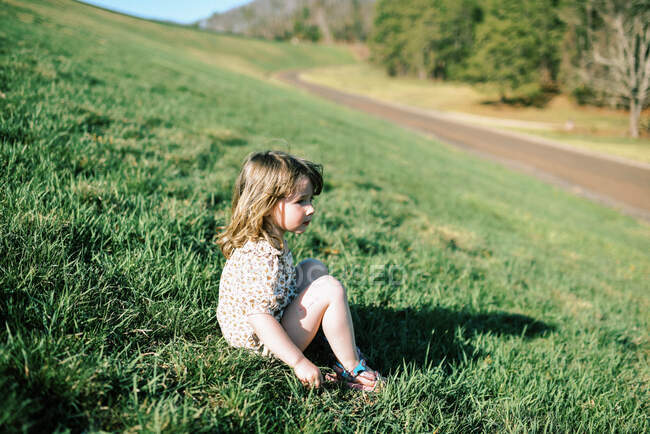 Petite petite fille assise sur le côté d'une digue en Nouvelle-Angleterre — Photo de stock