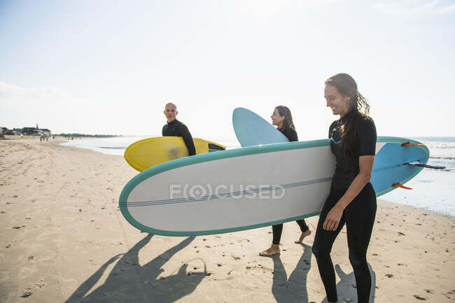 Groupe d'amis surfeurs lors d'un lever de soleil estival surf — Photo de stock