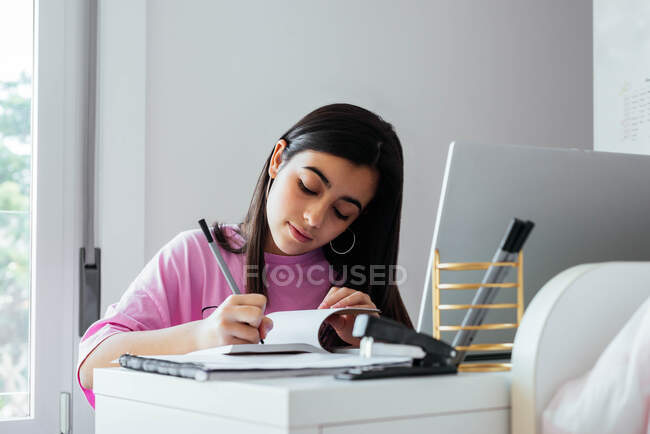 Konzentrierter Teenager lernt am Schreibtisch im persönlichen Raum — Stockfoto