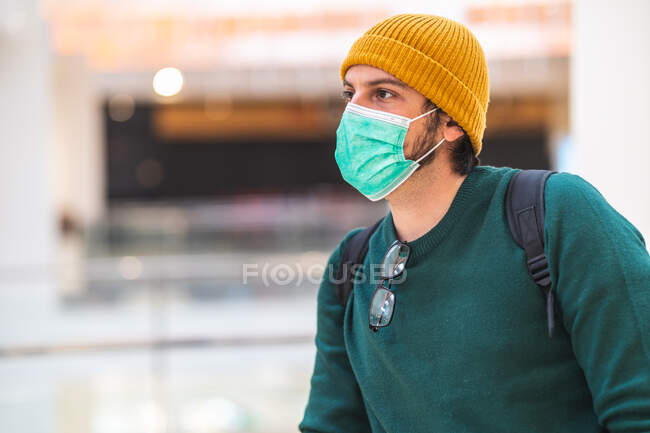 Современный испанский человек в зеленой защитной маске в торговом центре — стоковое фото