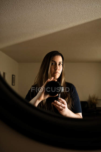 Жінка фотографує себе у дзеркалі у вітальні — стокове фото