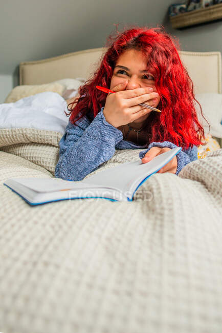 Gen Z Laughing to herself while writing in journal — Stock Photo