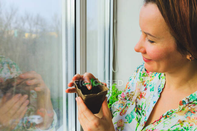 A girl photographs potted plants that she has grown in her home garden — Stock Photo