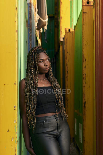 Femme noire vêtue de vêtements urbains avec des tresses dans les cheveux — Photo de stock