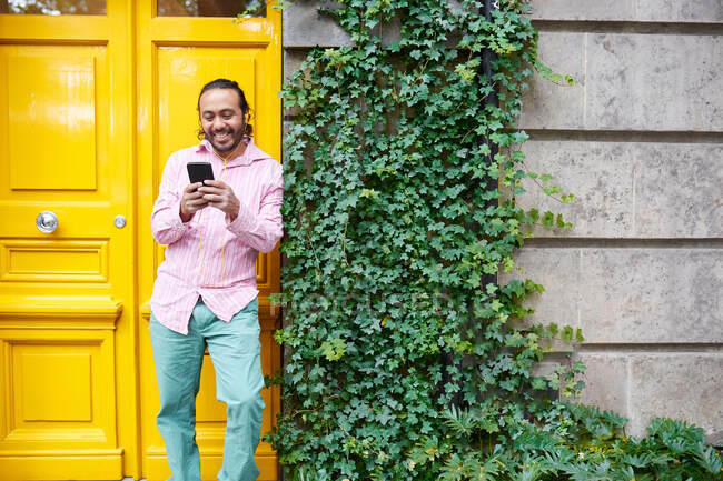 Счастливый молодой человек слушает музыку с помощью смартфона на улице — стоковое фото