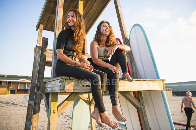 Zwei Freundinnen, die im Sommer bei Sonnenaufgang surfen — Stockfoto