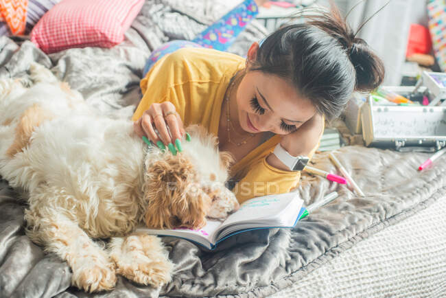 Gen Z schreibt in ihrem Tagebuch mit ihrem Hund — Stockfoto