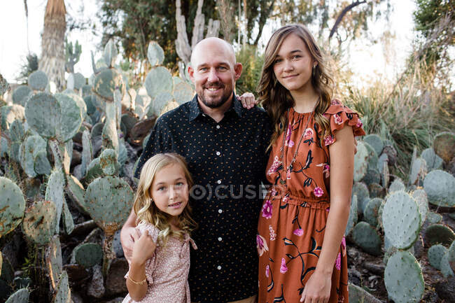 Portrait of father and daughters together in garden — Stock Photo