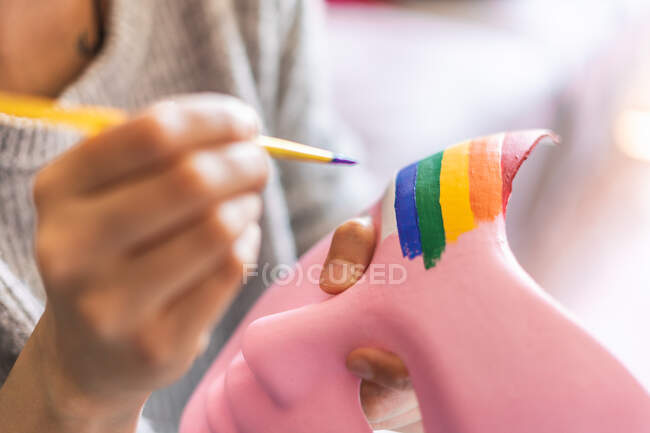 Painter giving blue brushstroke on pink painted mask for pride day — Stock Photo
