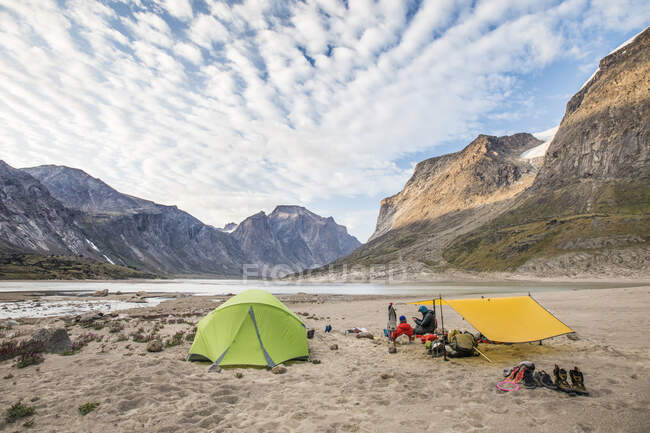 Задний вид альпинистов, отдыхающих в базовом лагере после долгого дня восхождения — стоковое фото