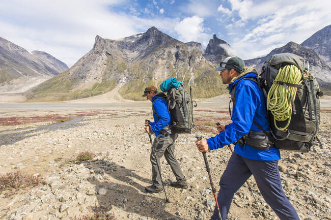 Due escursionisti escursionisti attraverso la valle montuosa, Isola di Baffin — Foto stock