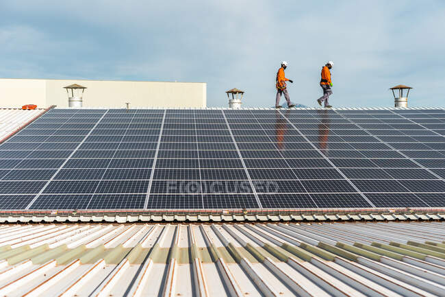Solar panel installation with unrecognizable technicians working — Stock Photo