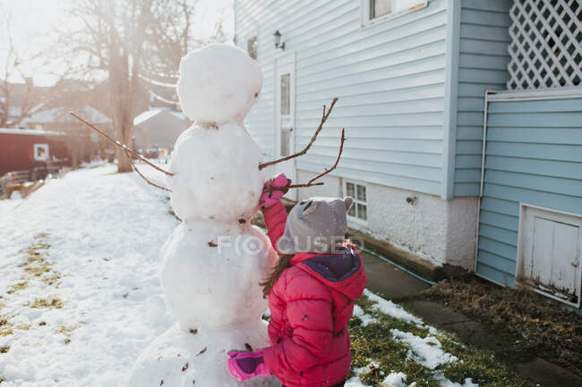 Vater und Tochter bauen Schneemann vor Haus — Stockfoto
