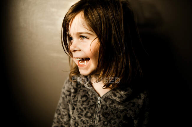 Young girl wearing a leopard pajamas laughing in the afternoon — Stock Photo