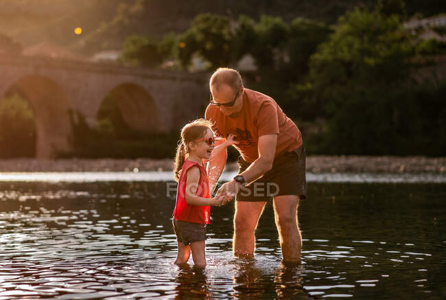 Father and daughter play in river in France in summer — Stock Photo
