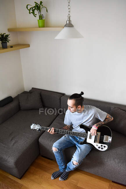 Ein junger Mann spielt eine Bassgitarre — Stockfoto