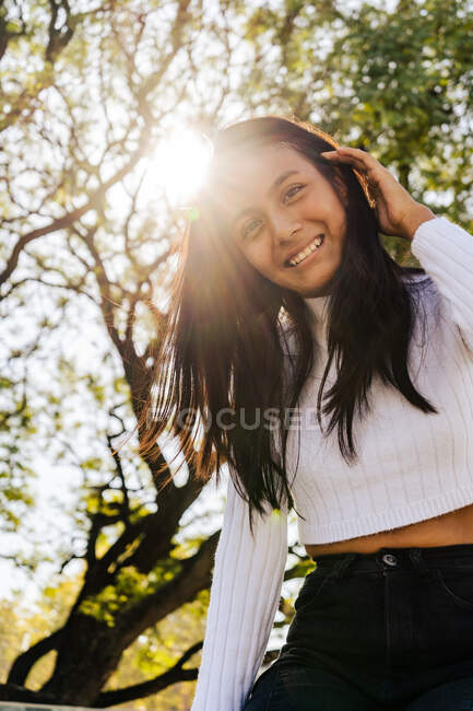 Donna sorridente con luce solare autunnale da dietro. — Foto stock