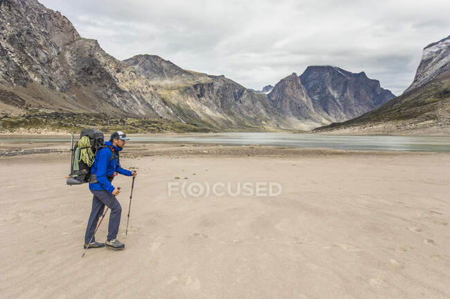 Backpacker traverses across sandy landscape on Baffin Island. — Stock Photo