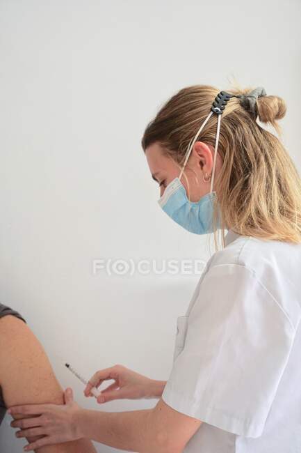 Vaccin mis jeune infirmière avec la main — Photo de stock
