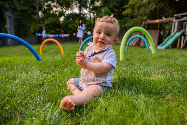 Adorável bebê senta-se no quintal — Fotografia de Stock