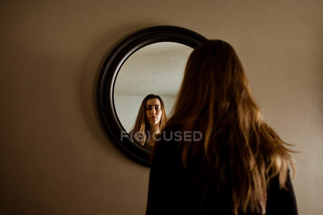 Жінка дивиться на себе у дзеркало — стокове фото