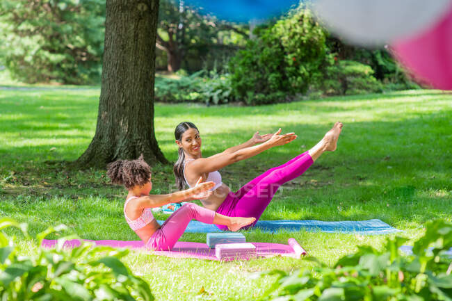 Mother & Daughter stretching in yard — Stock Photo