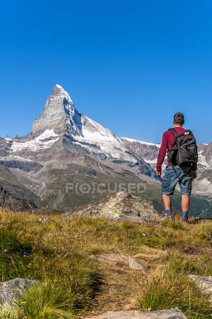 Caminante caucásico macho viendo Matterhorn, uno de los más famosos - foto de stock