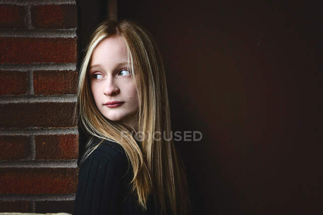 Beautiful tween girl with blond hair looking thoughtful. — Stock Photo