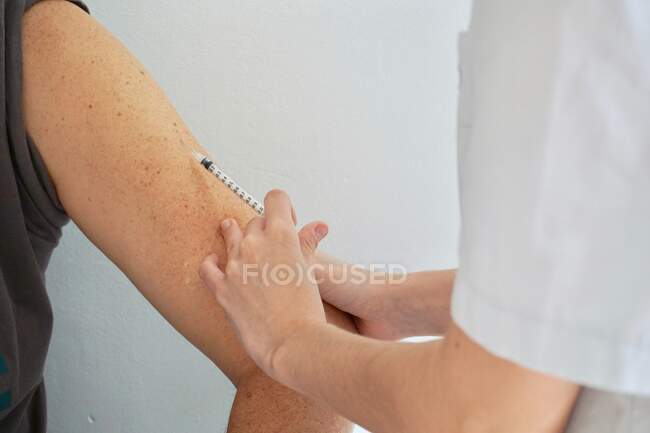 Vacina colocar jovem enfermeira com a mão — Fotografia de Stock