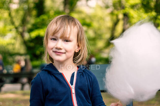 Мила молода дівчина 3-4 роки їсть бавовняні цукерки — стокове фото