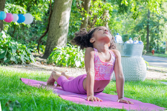 Young girl practicing yoga in backyard — Stock Photo